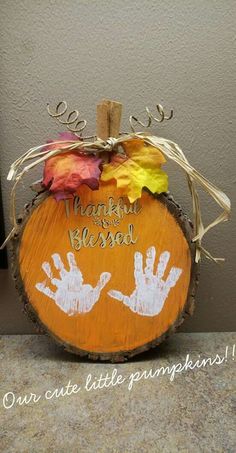 a wooden pumpkin with handprints on it