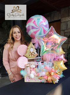 a woman standing next to a table filled with candy and balloons