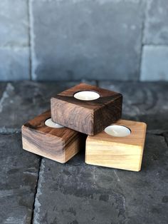 three wooden candlesticks sitting on top of each other in front of a stone wall