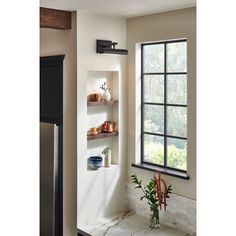 a kitchen with an open window and shelves on the wall, next to a refrigerator