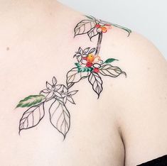 a woman with a tattoo on her upper back shoulder and flowers in the lower arm