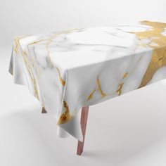 a white and gold marble table cloth on a wooden base with pink legs, against a white background