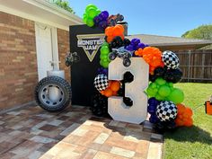 the letter b is made out of balloons and other items in front of a house