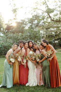 a group of women standing next to each other on top of a lush green field