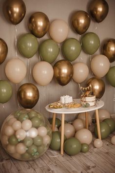 a table topped with a cake next to balloons