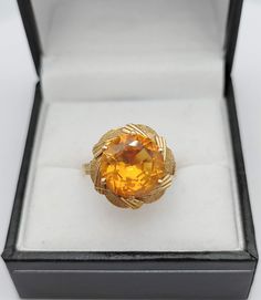 Large round cut orange sapphire set on a 18K gold ring The sapphire, possibly synthetic, measures 11 x 6.3 mm and weighs approx 6 Ct. It is loupe clean of any inclusion, giving a very nice flamboyant and warm effect. The flower design is typical of the 1950s era Weight of the ring : 5 Gr Size : US 6 3/4 - UK N 1/2 - FR 54 Possibility to resize for a flat fee of 40 euros equivalent. Please allow 6-9 working days for the modification to be done as we do not perform the alteration ourselves but use Orange Sapphire Ring For Formal Occasions, Orange Sapphire Round Ring, Formal Orange Oval Rings, Orange Topaz Round Ring, Antique Orange Rings For Formal Occasion, Formal Citrine Orange Rings, Classic Orange Topaz Ring With Prong Setting, Orange Topaz Round Ring For Anniversary, Formal Orange Rings With Center Stone