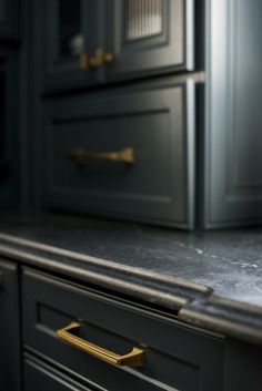 a kitchen counter top with gold handles and drawers