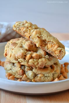 two cookies stacked on top of each other in front of a white plate with nuts