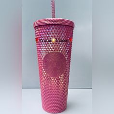 a pink tumbler cup with a straw in the shape of a lion on it