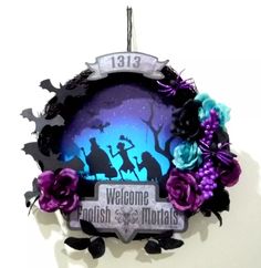 the welcome sign is decorated with purple flowers and black silhouettes in front of a full moon