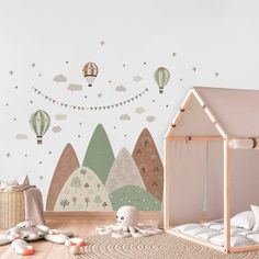 a child's room decorated in pastel colors with hot air balloons and mountains