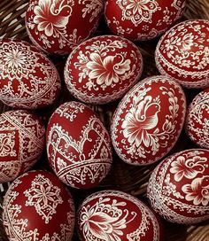 many red and white decorated eggs in a basket