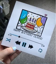 a person holding up a birthday card with balloons and a cake in the background that says happy birthday silver