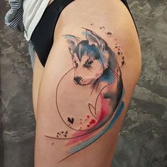 a woman's thigh with a watercolor husky dog tattoo on her left side