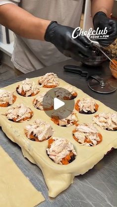 a person in black gloves making cupcakes on a table