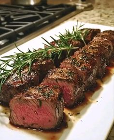 steak on a plate with garnish and seasoning next to a stove top