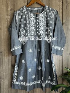 Unique denim look Chikankari hand embroidered blouse with side slits. Length: 32 inches Traditional Cotton Top For Eid, Spring Cotton Kurta With Motifs, Festival Embroidered Straight Kurta Top, Fitted Cotton Folk Kurta, Traditional Chikankari Embroidered Top, Traditional Tunic With Resham Embroidery, Traditional Resham Embroidered Tunic Top, Cotton Long Sleeve Tops With Cutdana, Casual Cotton Kurta With Embroidery