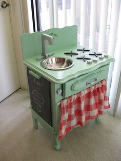 an old fashioned kitchen with a sink and stove in the middle, next to a window