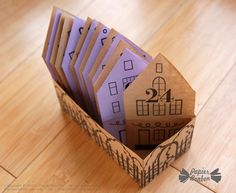 an open cardboard box filled with lots of purple cards on top of a wooden floor