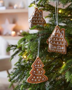 three gingerbread christmas ornaments hanging from a tree