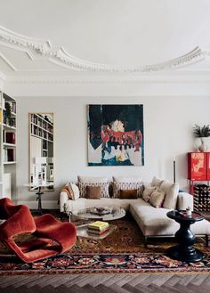 a living room filled with furniture and a painting on the wall