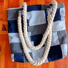 a blue and white tote bag sitting on top of a wooden floor