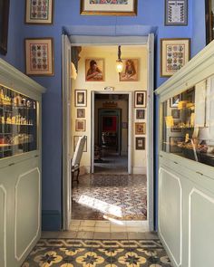 an entry way with pictures on the wall and tile flooring in front of it