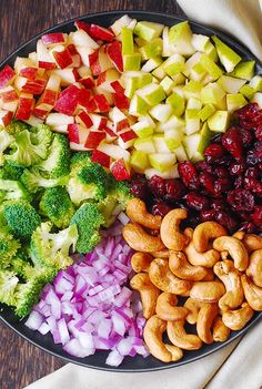 an assortment of fruits and vegetables are arranged in a platter on a wooden table