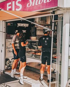 two men standing in front of a food stand