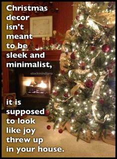 a christmas tree is decorated with red and gold ornaments in front of a fire place that reads, it is supposed to look like joy threw up in your house