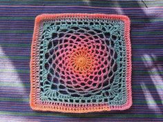 a crocheted square on top of a blanket