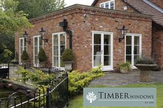 a brick house with white windows and black iron fence