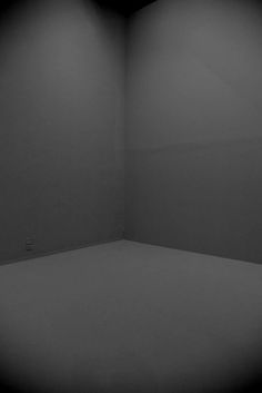 an empty room with white walls and no one is in it at the far end