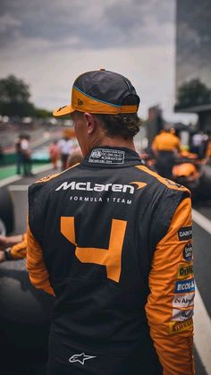 a man in an orange and black racing uniform