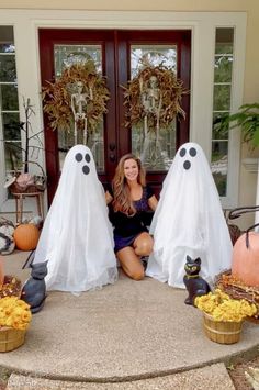 a woman sitting in front of a door decorated with fake ghost heads and pumpkins