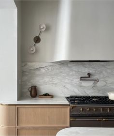 a stove top oven sitting inside of a kitchen next to a wall mounted light fixture