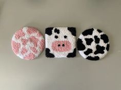 three cow coasters are shown on a table