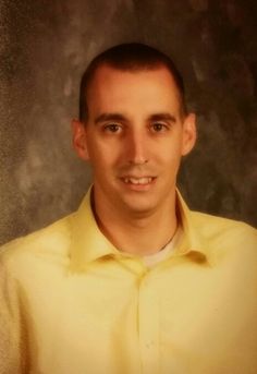 a man in a yellow shirt posing for a photo