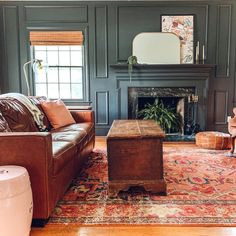 a living room filled with furniture and a fire place next to a mirror on the wall