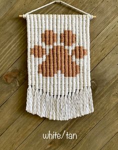 an orange and white woven wall hanging on a wooden floor with text overlay that reads,'white / tan '