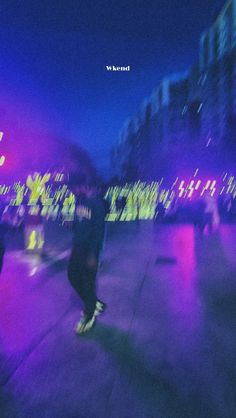 blurry image of people walking in the city at night with bright lights on them