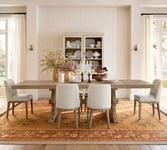 a dining room table with chairs and plates on it