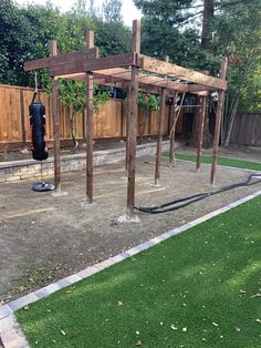 an outdoor play area with swings, climbing bars and a punching bag in the background