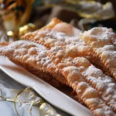 some food is on a white plate with gold trimmings and other items in the background