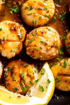 shrimp and scallops in a sauce with lemon wedges