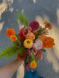 a person's hand holding a bouquet of flowers