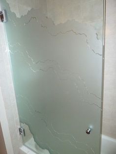 a glass shower door in a bathroom next to a bathtub with no curtain on it