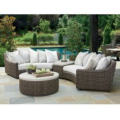 an outdoor patio furniture set with pillows on the couch and coffee table next to it