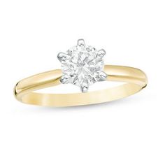 a yellow gold engagement ring with a round diamond in the center, on a white background