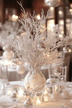 the centerpieces are decorated with silver and white balls, branches, and snowflakes